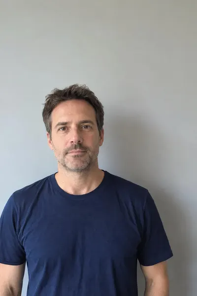 Before: Man in a navy t-shirt standing in front of a grey-blue wall
