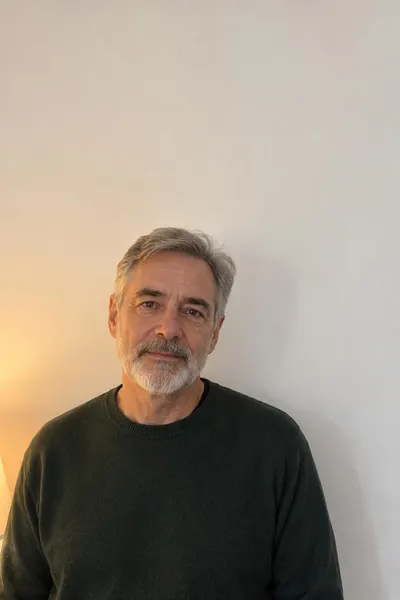 Before: Older man in a green sweater lit by a warm lamp
